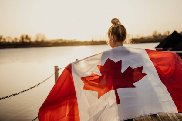 A girl holds the flag of Canada.